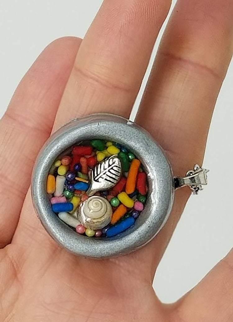 Round gray clay pendant filled with real candy sprinkles, metal leaf and tiny seashell immersed in resin - Includes chain - Curio Memento