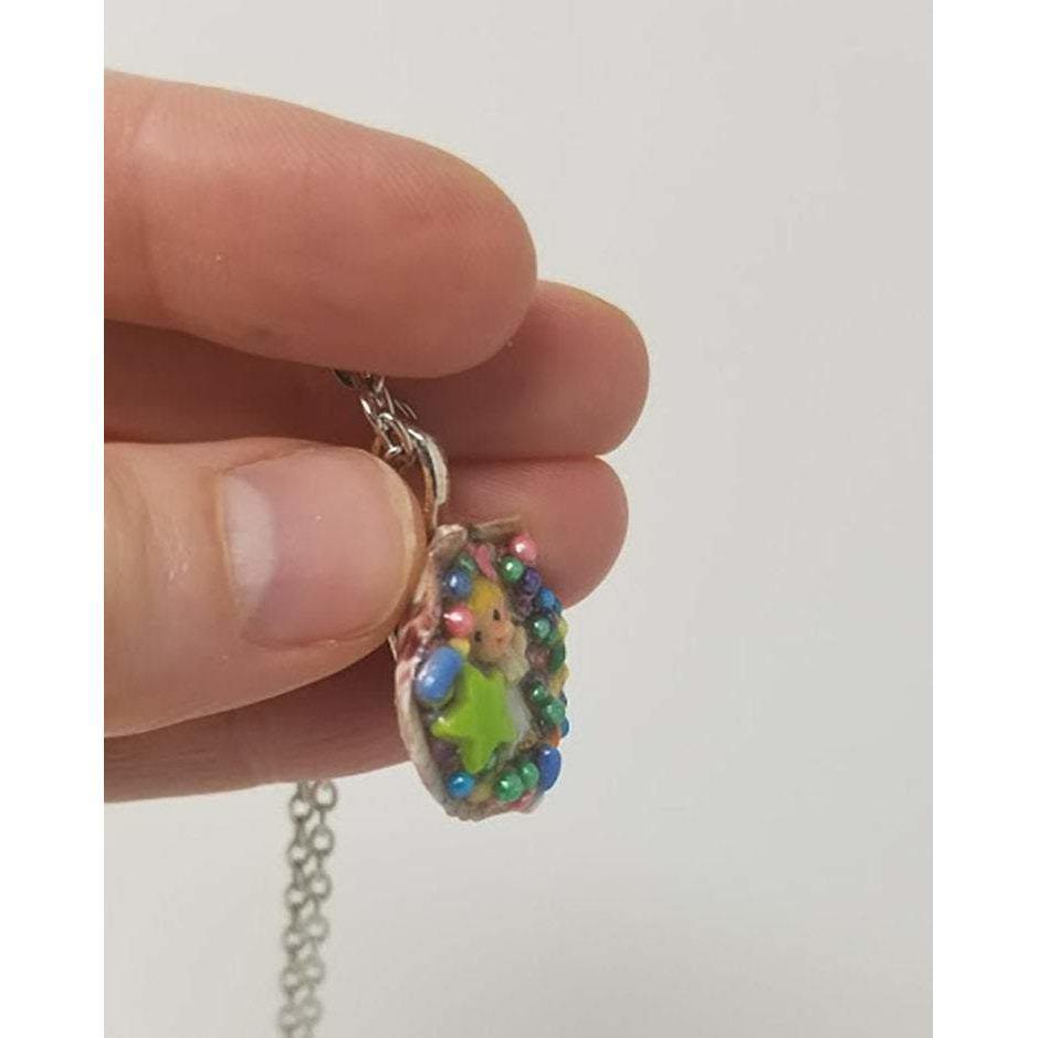 Seashell pendant created using antique miniature angel, candy sprinkles, sequins and resin. Includes 18" chain - Curio Memento